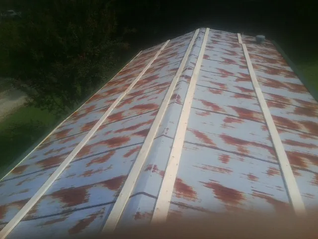 Rusted metal roof panels with new wood purlins before replacement — Storm Damage Roof Repair in Edgewater by Roofing Brothers