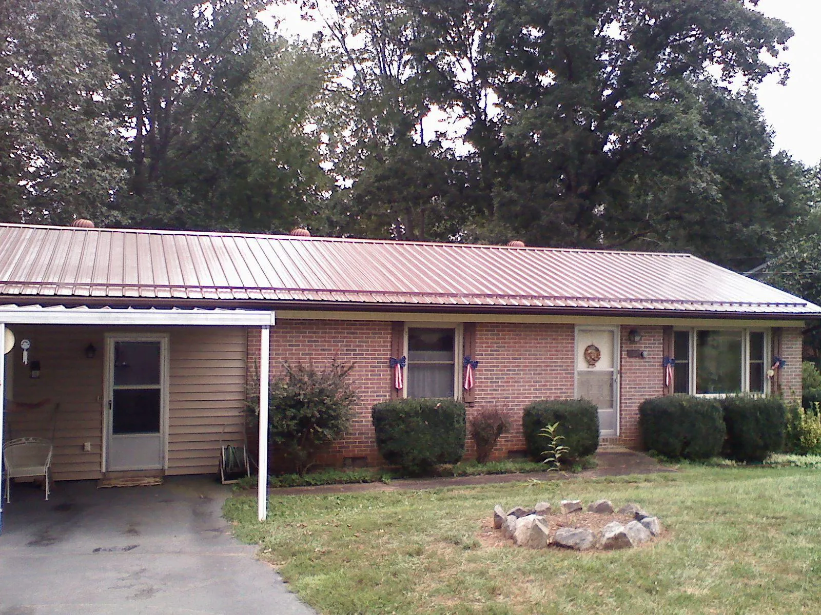 Bronze metal roof and carport on a brick ranch home — Roof Repair work by our crew in Edgewater